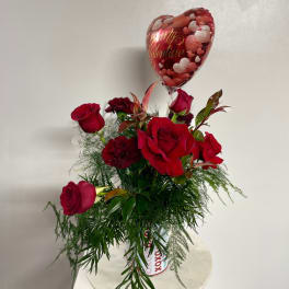 Red roses in a vase with a heart-shaped Valentine balloon
