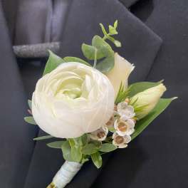 White boutonniere with a ranunculus bloom and small white flowers