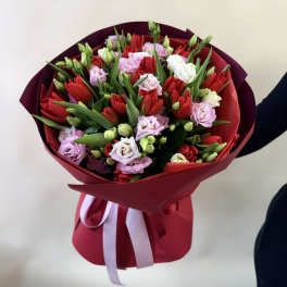 Bouquet of red, pink, and white tulips wrapped in burgundy paper