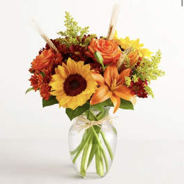 Bouquet of orange and yellow flowers in a clear glass vase