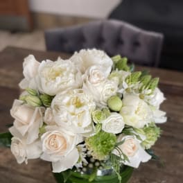 White and blush bouquet in a green glass vase