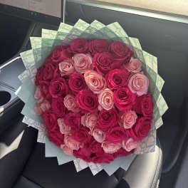 Bouquet of pink and magenta roses wrapped in patterned paper