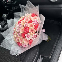 Bouquet of pink and red roses wrapped in translucent striped paper