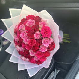 Bouquet of pink and red roses wrapped in translucent paper