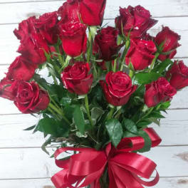 Bouquet of red roses in a glass vase with a red ribbon