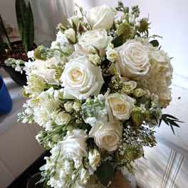 White rose bouquet with mixed white blooms in a glass vase