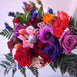 Handheld bouquet of multicolored roses and mixed blooms