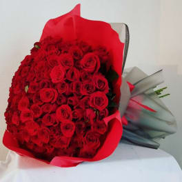 Large bouquet of red roses wrapped in red and gray paper