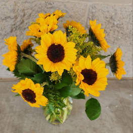 Bouquet of yellow sunflowers in a clear glass vase