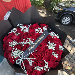 Bouquet of red roses with white baby's breath in black wrap