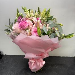 Pink bouquet with roses and lilies wrapped in pink paper