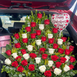 Large red and white rose arrangement in a wooden box with a Valentine balloon