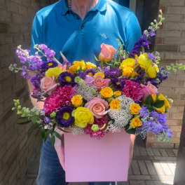 Mixed bouquet in a pink box with roses and purple blooms