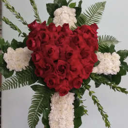 Red rose and white carnation cross-shaped floral tribute on an easel