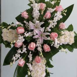 Standing floral cross with pink roses, white lilies, and white blooms