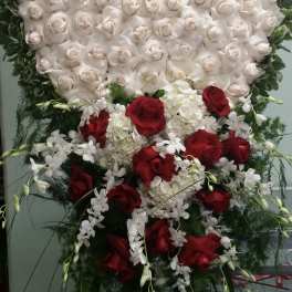 Heart-shaped white rose arrangement with red roses and white orchids below
