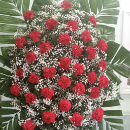 Large standing spray of red carnations and white baby's breath