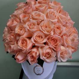 Bouquet of peach roses in a white hatbox