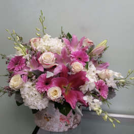 Pink and white mixed flower arrangement in a decorative box
