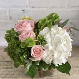 Pink roses and white hydrangea in a glass vase