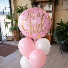 Pink and white balloons with a large "It's a Girl" balloon