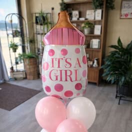 Pink and white baby girl balloon bouquet with a large bottle-shaped balloon