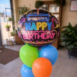 Birthday balloon bouquet with a neon-style foil balloon and colorful latex balloons