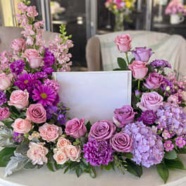 Pink and purple floral wreath with roses and hydrangeas around a blank center