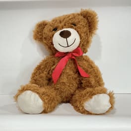 Brown teddy bear with a red ribbon bow