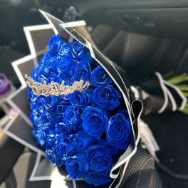 Bouquet of vivid blue roses wrapped in black and white paper
