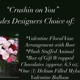 Valentine bouquet in a glass vase with a stuffed animal, chocolates, and a balloon