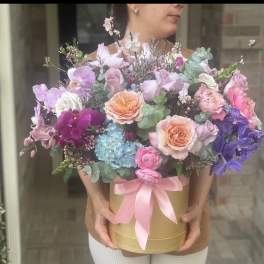 Large pastel bouquet in a gold box with a pink ribbon