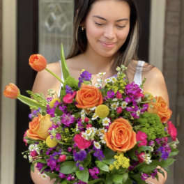 Woman holding a colorful bouquet in a glass vase