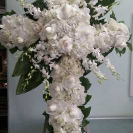 Large white floral cross arrangement with roses and orchids