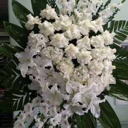 Large white funeral spray with lilies and roses