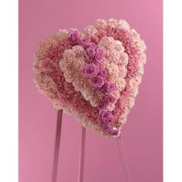 Heart-shaped pink floral arrangement on a stand
