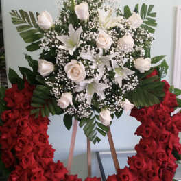Large floral wreath with red and white roses on a stand