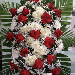 Standing floral spray with red roses, white blooms, and palm leaves