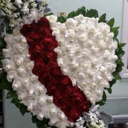Heart-shaped rose arrangement with red and white roses on an easel