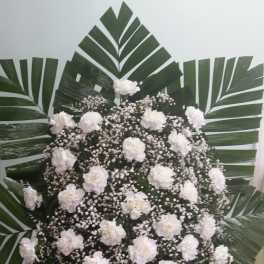 White carnation standing spray with palm fronds