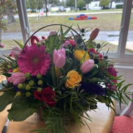 Mixed bouquet with pink tulips, roses, and a large magenta gerbera daisy