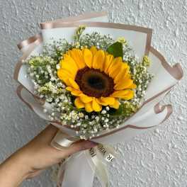 Handheld bouquet with a sunflower and small white filler flowers