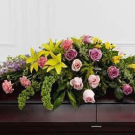 Casket spray with pink roses and yellow lilies