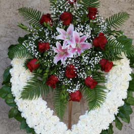 Heart-shaped floral wreath with red roses, pink lilies, and white flowers
