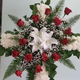 Cross-shaped floral tribute with red roses and white lilies