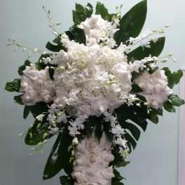 Tall white floral cross with roses and orchids