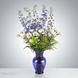 Blue and white mixed bouquet in a cobalt glass vase