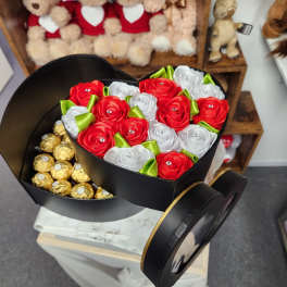 Heart-shaped box with red and white ribbon roses and gold-wrapped chocolates