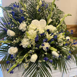 White and blue funeral spray with lilies and roses