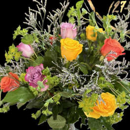 Mixed roses in a clear glass vase with silver filler